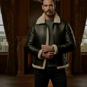 A man wearing a black leather aviator jacket with a cream shearling collar in a luxury room.